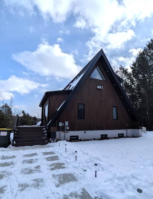 VIEW of the cottage from the driveway, showing off its A-frame construction.