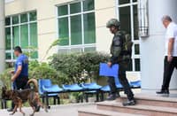 A BOMB-SNIFFING K9 is being led into the Quezon City Hall of Justice following reports of the presence of a bomb inside the building on Friday morning.