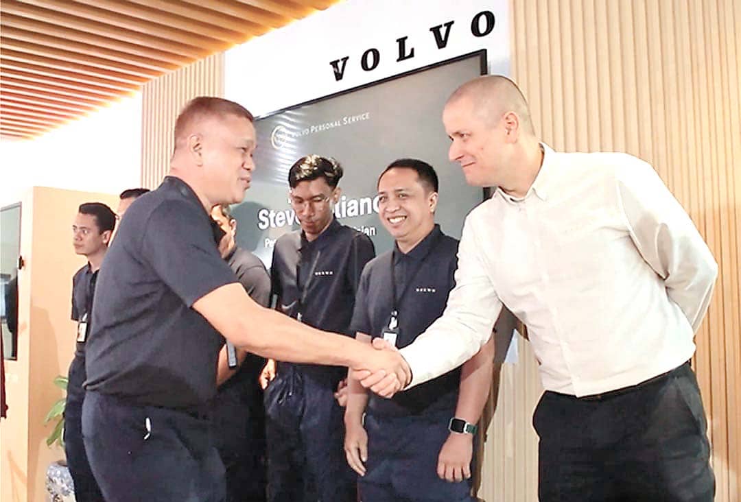 CERTIFICATION moment as a Volvo representative shakes hands with a newly certified Personal Service Technician.