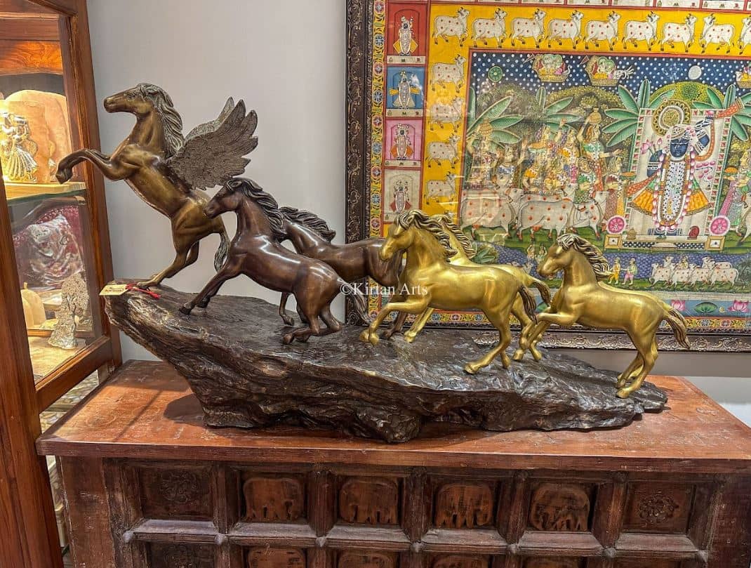 BRASS horse sculpture paired with warm wood and soft ambient lighting.