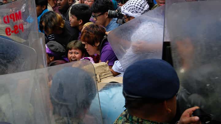 ACTIVISTS and allies from left-leaning groups push against police barricades on Kalaw Avenue in Manila, Sunday. The group marched toward the US Embassy on International Women’s Day to protest, among other things, US-Israeli military actions involving Iran.
