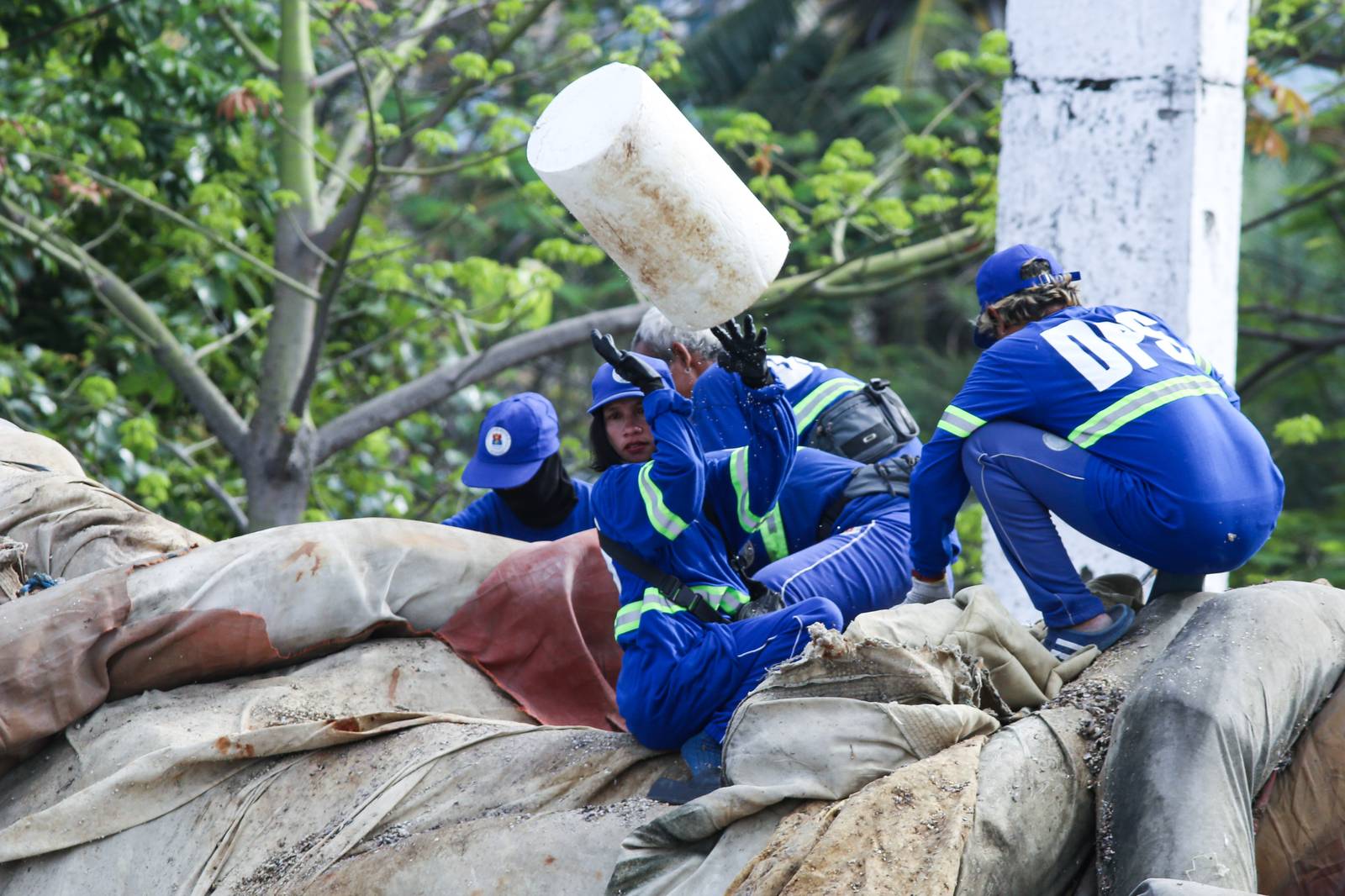 Department of Environment and Public Services personnel remove broken floating barriers in Manila Bay on Saturday, 14 March 2026. The barriers, which had long been piled at the edge of Dolomite Beach, were originally used to mark the area and prevent debris from drifting further into the water.