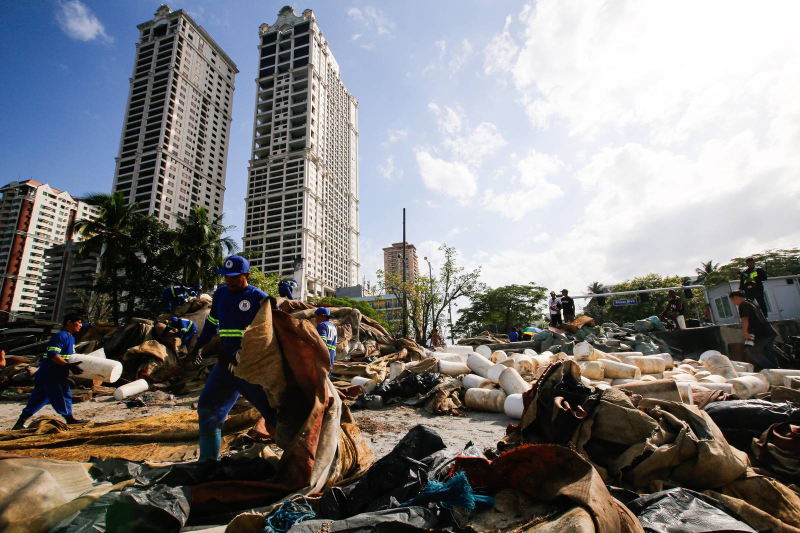 Department of Environment and Public Services personnel remove broken floating barriers in Manila Bay on Saturday, 14 March 2026. The barriers, which had long been piled at the edge of Dolomite Beach, were originally used to mark the area and prevent debris from drifting further into the water.