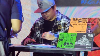 GLOC-9 signs copies of his chapbooks for readers during the launch.
