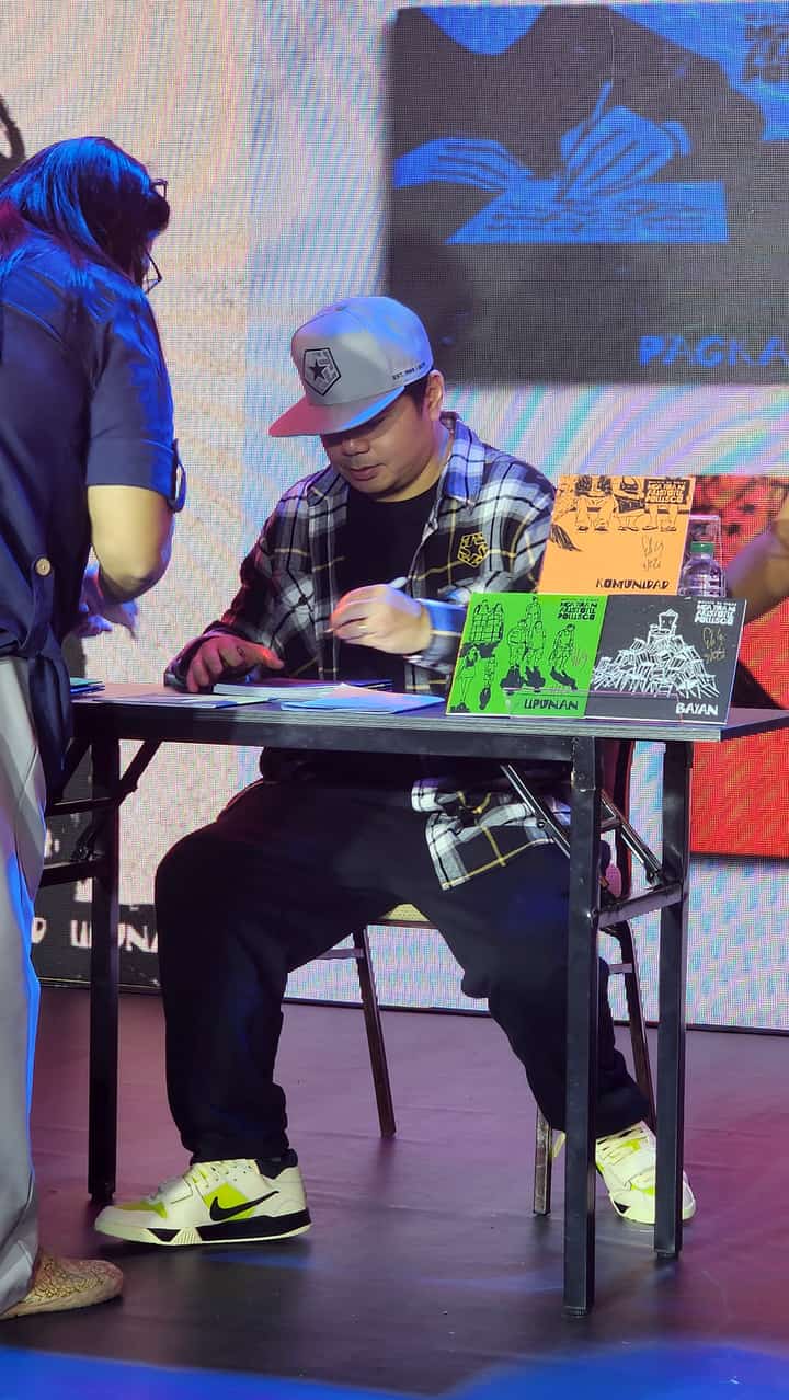 GLOC-9 signs copies of his chapbooks for readers during the launch.