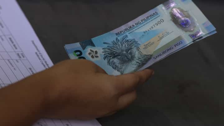 Tricycle drivers receive ₱5,000 in cash assistance during a DSWD payout at the Dakota Covered Court in Ermita, Manila last March 16.