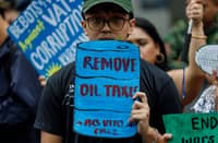 Student activists stage a protest in front of a gas station in Manila, demanding the government to remove oil excise and VAT taxes amid the rising fuel prices caused by the escalating conflict in the Middle East, on Tuesday, 17 March 2026.