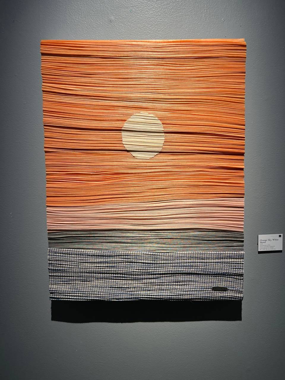 ORANGE Sky, White Moon, 2026, Handwoven raffia, abaca and spun polyester embroidered on canvas, 36” x 48.”