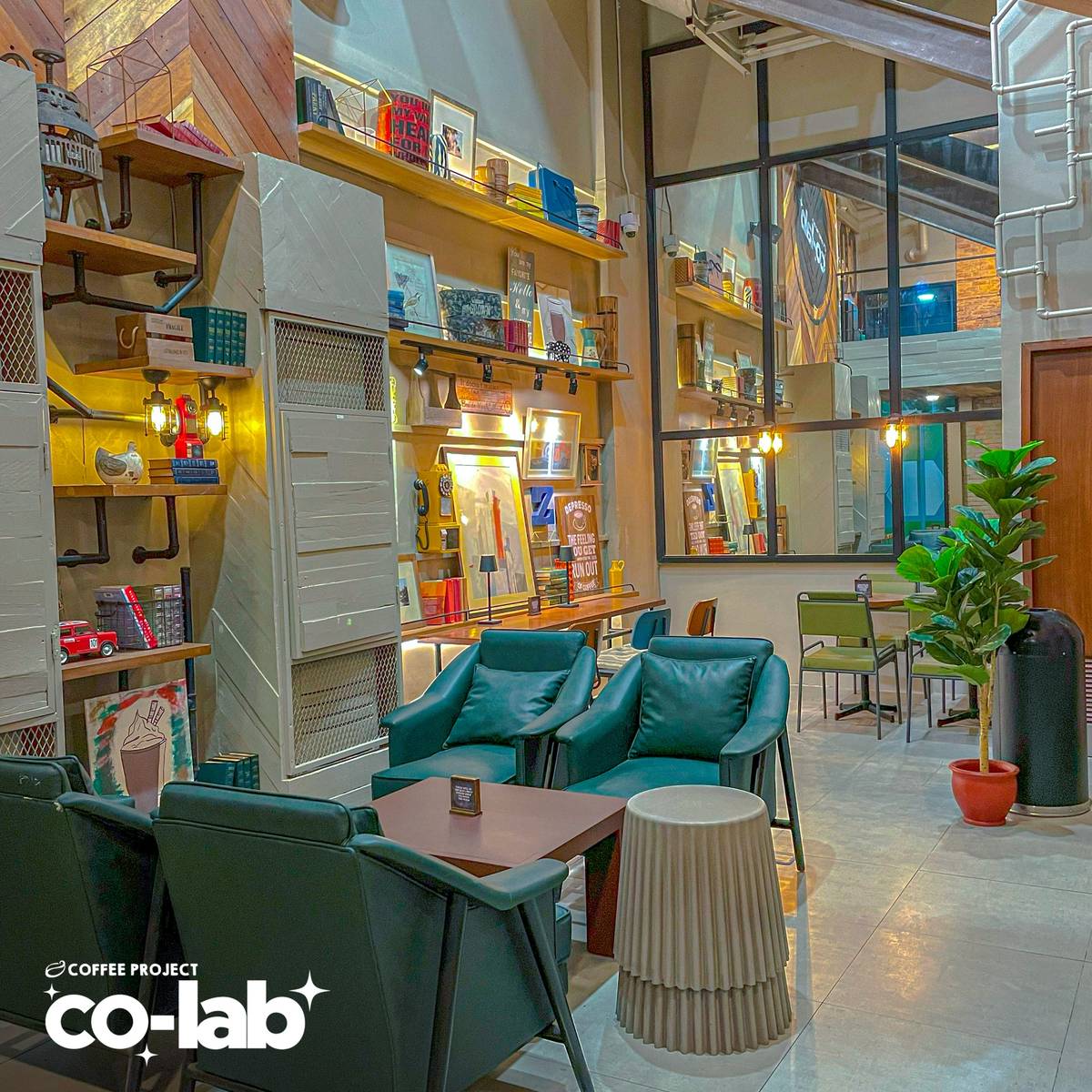 DEEP teal armchairs and floor-to-ceiling shelving create a sophisticated, industrial-style study hall designed for long-form focus.