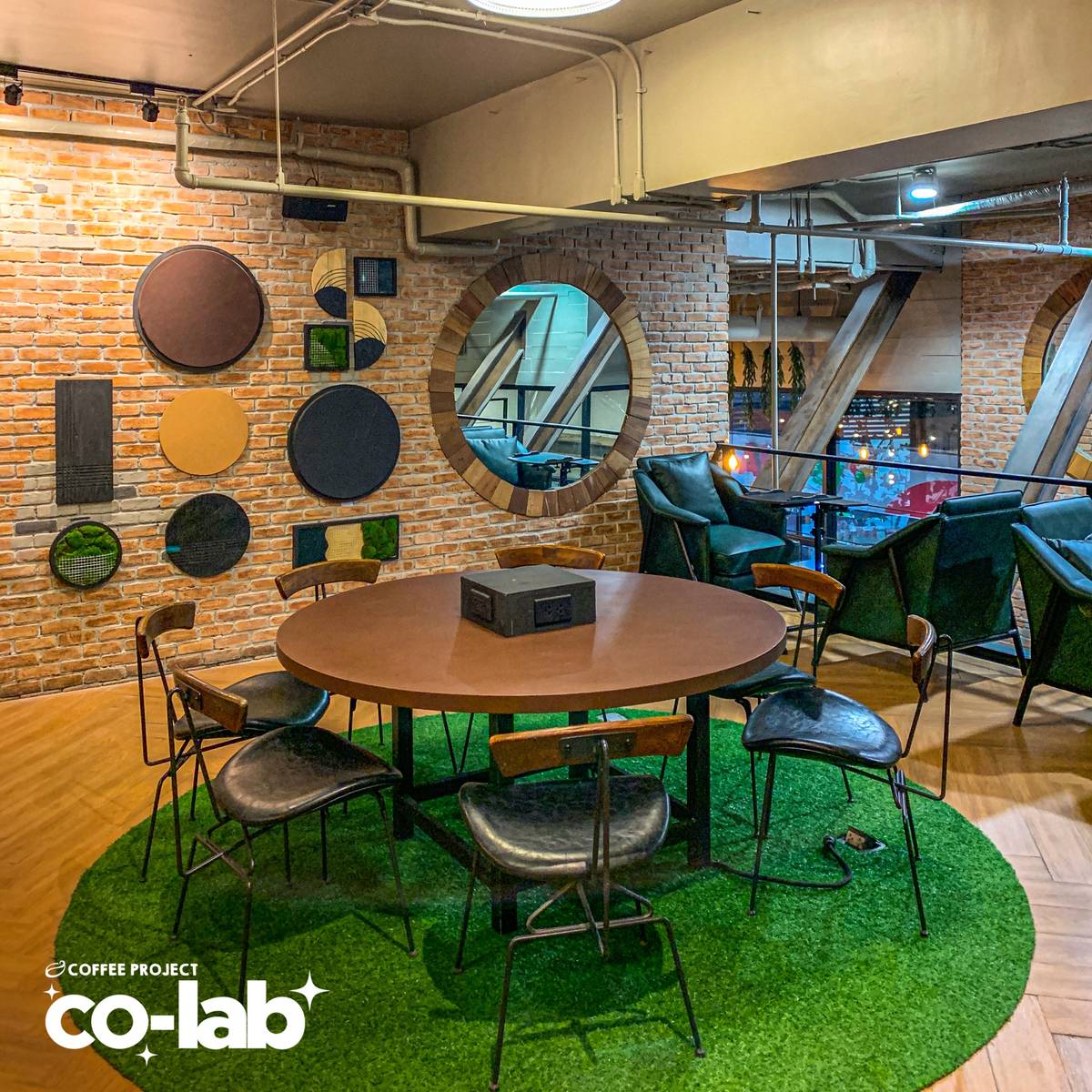 A round collaborative workstation featuring integrated power outlets sits atop a turf accent, streamlining group productivity in a modern setting.