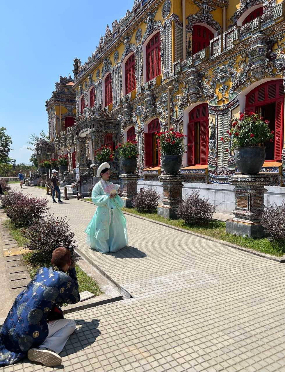 A photographer snaps a shot of a lady in áo dài.