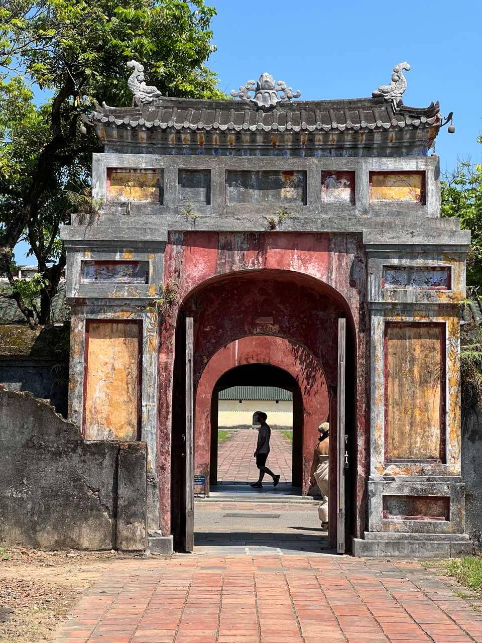 A man walks across one of the storied gates.