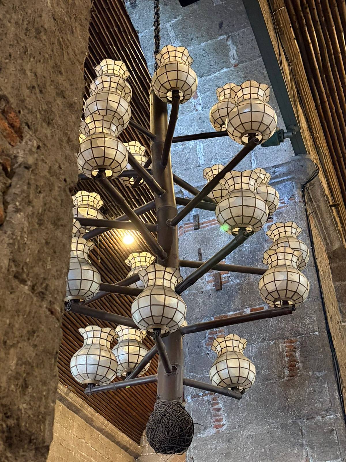 BAMBOO chandeliers paired with capiz lanterns cast a warm, natural glow inside the church.