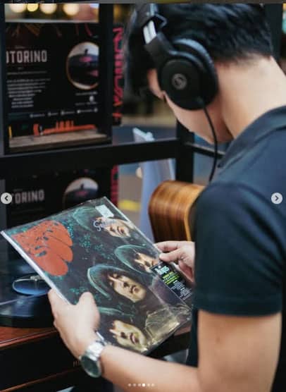 A young music lover checking out a vinyl record by The Beatles.