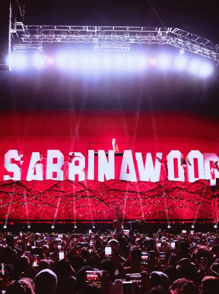 THE production transformed into a living film set, featuring a glowing marquee and shifting backdrops reminiscent of Old Hollywood soundstages.