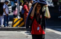 A PEDESTRIAN braves the midday heat while crossing the intersection of Taft Avenue and United Nations Avenue in Manila.