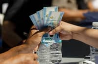 Jeepney drivers previously not included in the list of recipients for the subsidy line up to receive the P5,000 cash relief from the DSWD's AICS program at a court in Sta. Cruz, Manila on Wednesday, 15 April 2026.