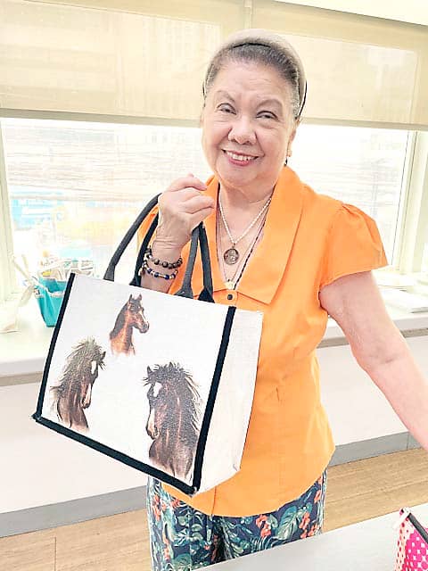 NENNE Bartolome holding a bag she designed.