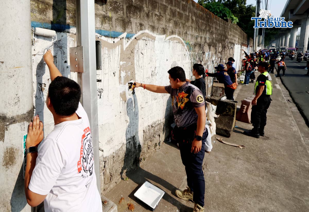 The QCPD and barangay officials cleared posters and other vandalism from a wall along Regalado Highway in Quezon City on Saturday, 18 April 2026, as part of Project Hilamos by the Quezon City government and the QCPD.