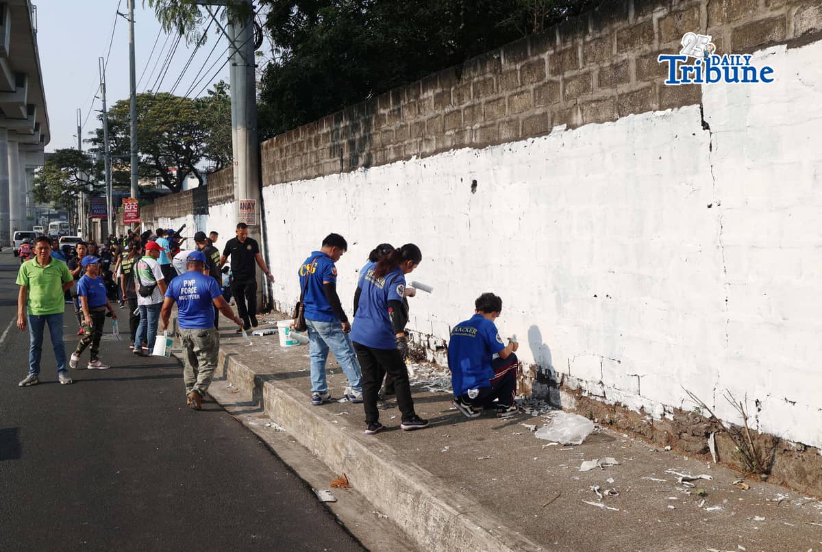 The QCPD and barangay officials cleared posters and other vandalism from a wall along Regalado Highway in Quezon City on Saturday, 18 April 2026, as part of Project Hilamos by the Quezon City government and the QCPD. Photo by Anie Labor.