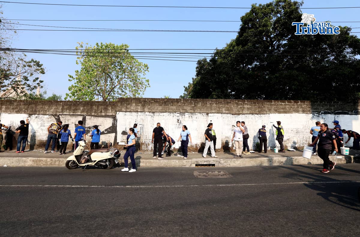 The QCPD and barangay officials cleared posters and other vandalism from a wall along Regalado Highway in Quezon City on Saturday, 18 April 2026, as part of Project Hilamos by the Quezon City government and the QCPD.