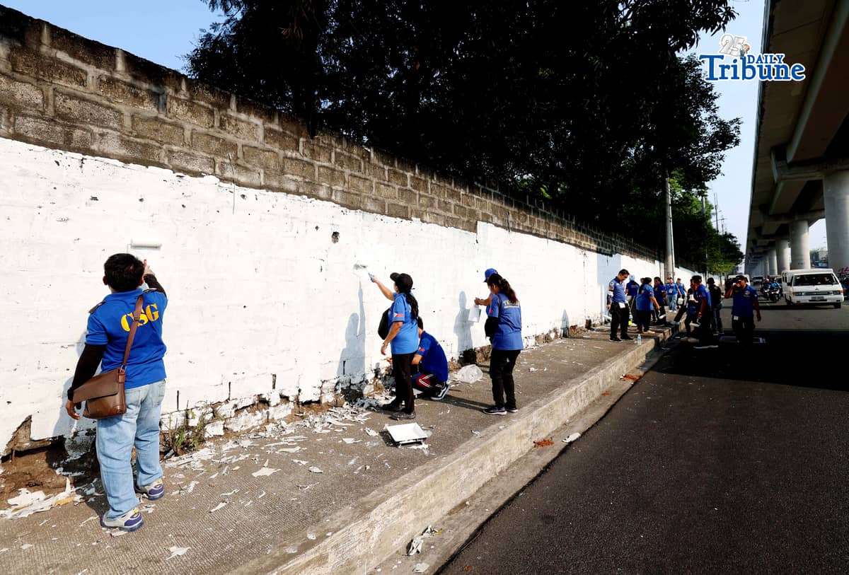 The QCPD and barangay officials cleared posters and other vandalism from a wall along Regalado Highway in Quezon City on Saturday, 18 April 2026, as part of Project Hilamos by the Quezon City government and the QCPD.