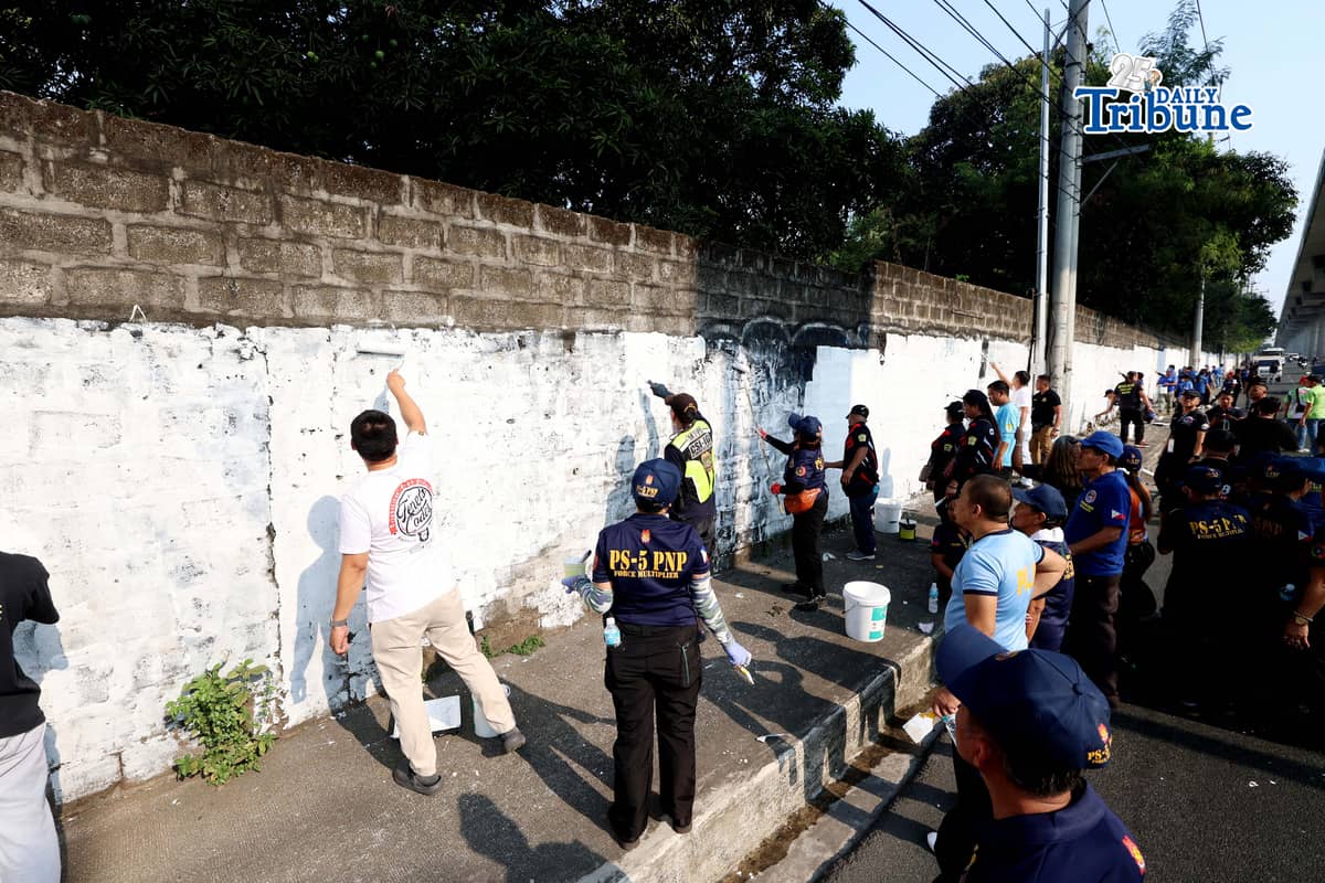 The QCPD and barangay officials cleared posters and other vandalism from a wall along Regalado Highway in Quezon City on Saturday, 18 April 2026, as part of Project Hilamos by the Quezon City government and the QCPD.