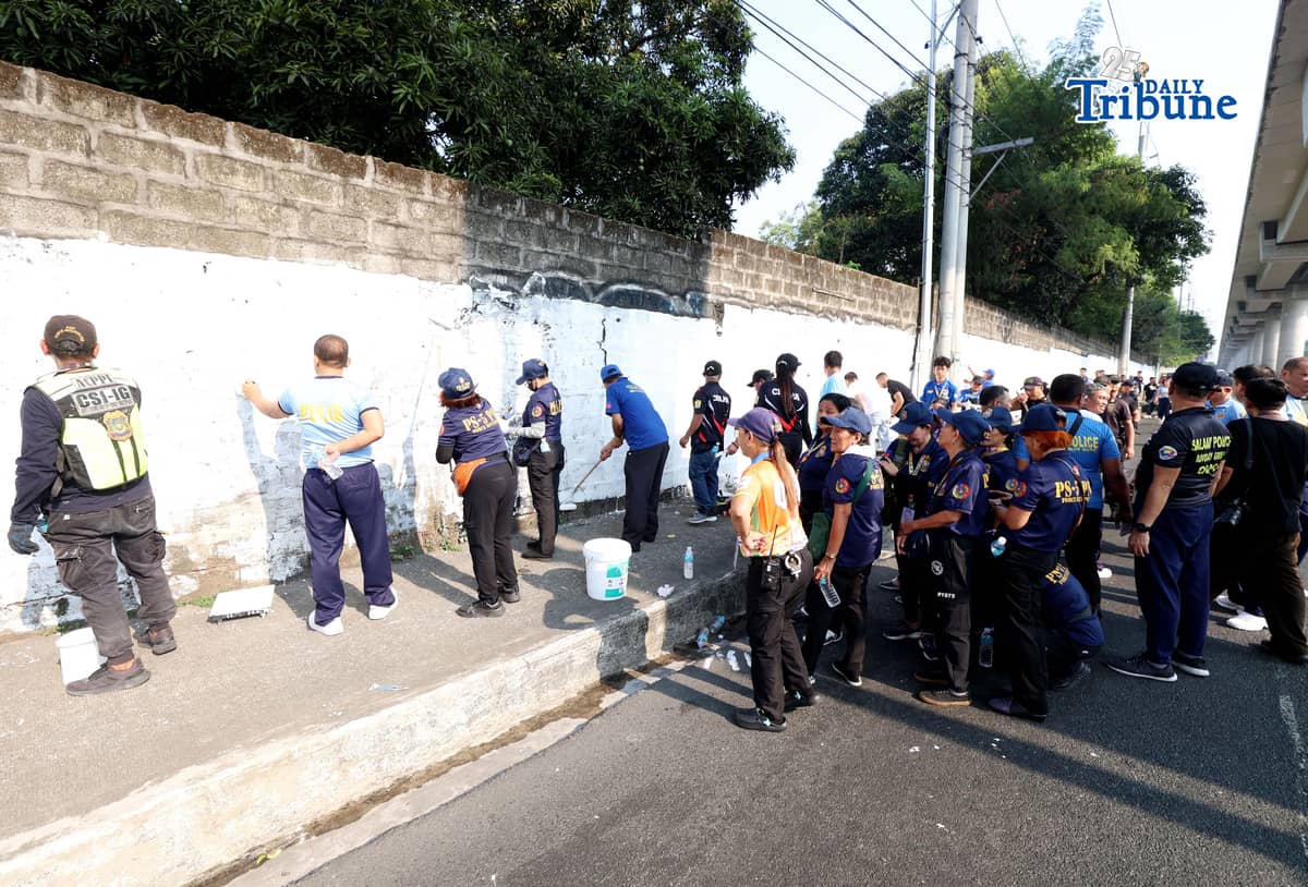 The QCPD and barangay officials cleared posters and other vandalism from a wall along Regalado Highway in Quezon City on Saturday, 18 April 2026, as part of Project Hilamos by the Quezon City government and the QCPD.