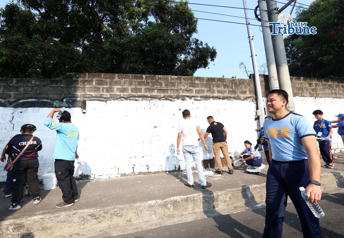 The QCPD and barangay officials cleared posters and other vandalism from a wall along Regalado Highway in Quezon City on Saturday, 18 April 2026, as part of Project Hilamos by the Quezon City government and the QCPD.