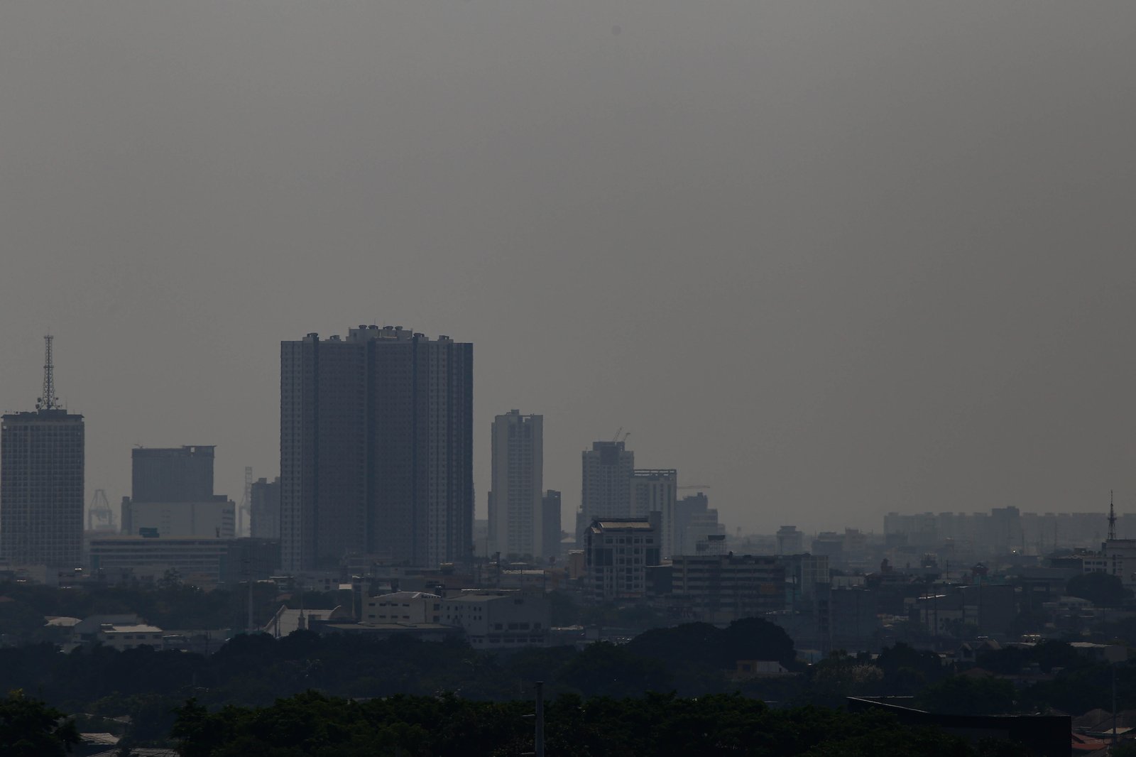 Haze continues to blanket Manila and neighboring cities today, 19 April 2026, as the Air Quality Index (AQI) reaches Moderate to Unhealthy for Sensitive Groups. Residents with respiratory conditions are strongly advised to limit prolonged outdoor activities. According to the DENR-EMB, Metro Manila is experiencing a "thermal inversion"—a phenomenon where warm air sits above cooler air, acting like a lid that traps pollution near the ground.