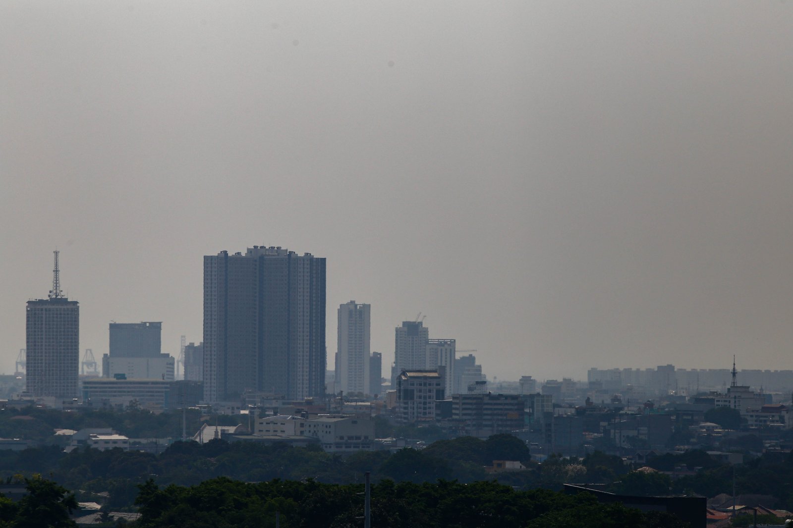 Haze continues to blanket Manila and neighboring cities today, 19 April 2026, as the Air Quality Index (AQI) reaches Moderate to Unhealthy for Sensitive Groups. Residents with respiratory conditions are strongly advised to limit prolonged outdoor activities. According to the DENR-EMB, Metro Manila is experiencing a "thermal inversion"—a phenomenon where warm air sits above cooler air, acting like a lid that traps pollution near the ground.