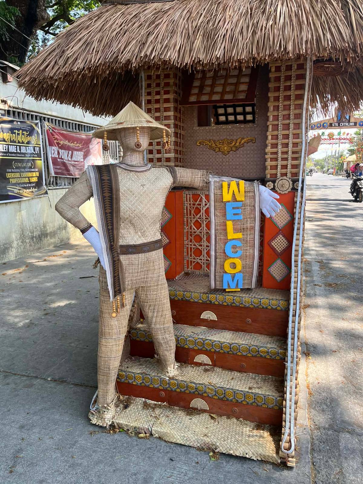 A life-sized woven human figure stands at the foot of the arch, lcoming everyone to Vega Grande.