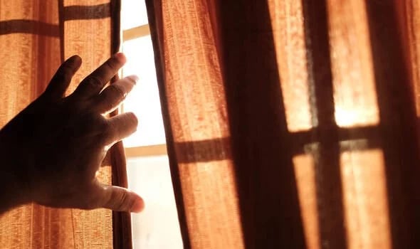 THICK curtains in the late morning to block intense sunlight, preventing heat buildup inside a modest urban home.