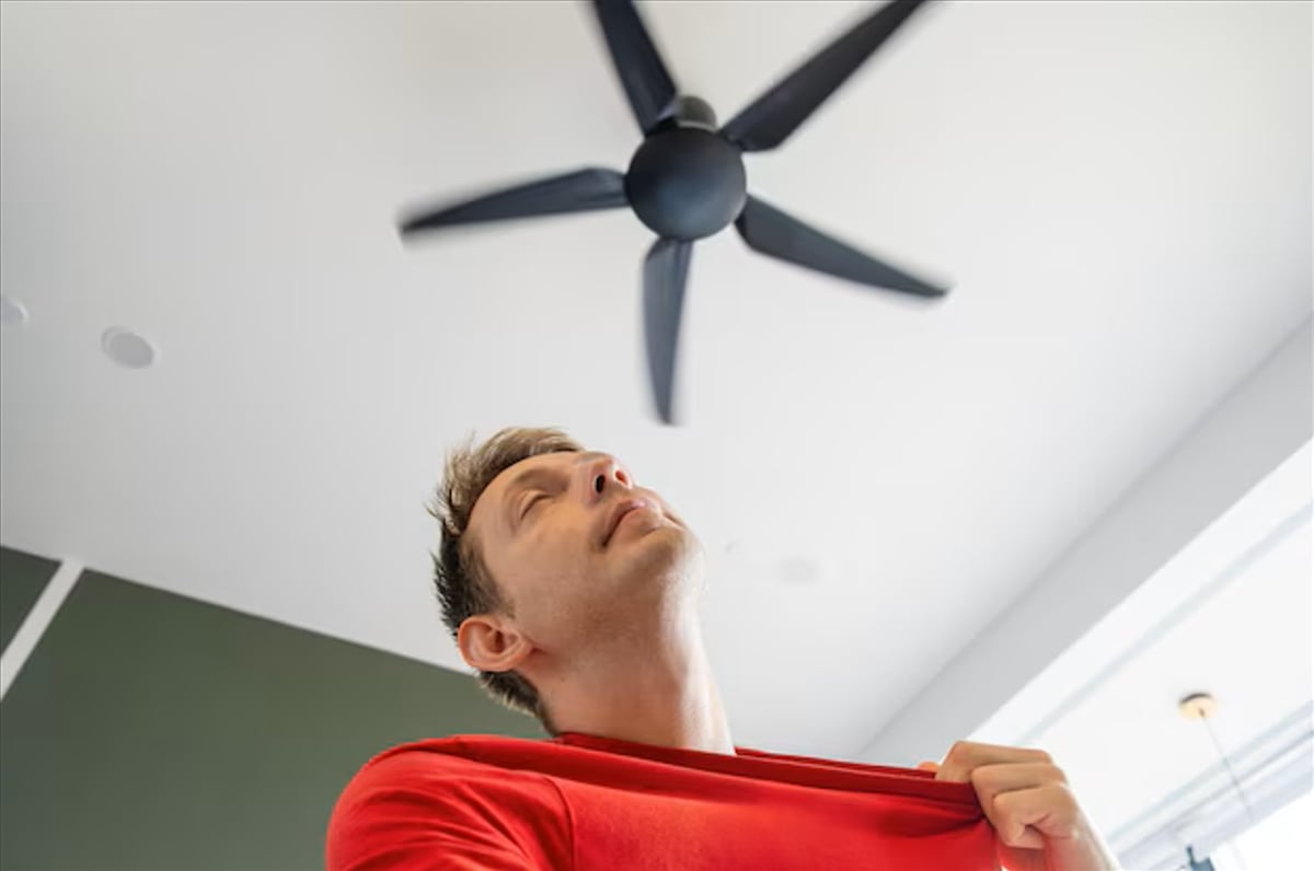 A CEILINGfan spins steadily in a living room, circulating air to ease the heat during a humid summer afternoon.