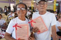 Two ARBs show off their CLOAs during the awarding of land certificates in Floridablanca, Pampanga on April 23, 2026.