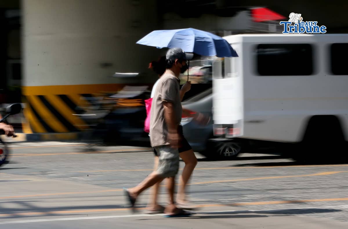 (April 24 2026) In Quezon City on Friday, April 24 2026, a pedestrian used an umbrella to protect herself from the heat of the sun, According to the PAGASA Metro Manila today face "extreme caution" to danger of heat index level (37°C–39°C). Photo/Analy Labor