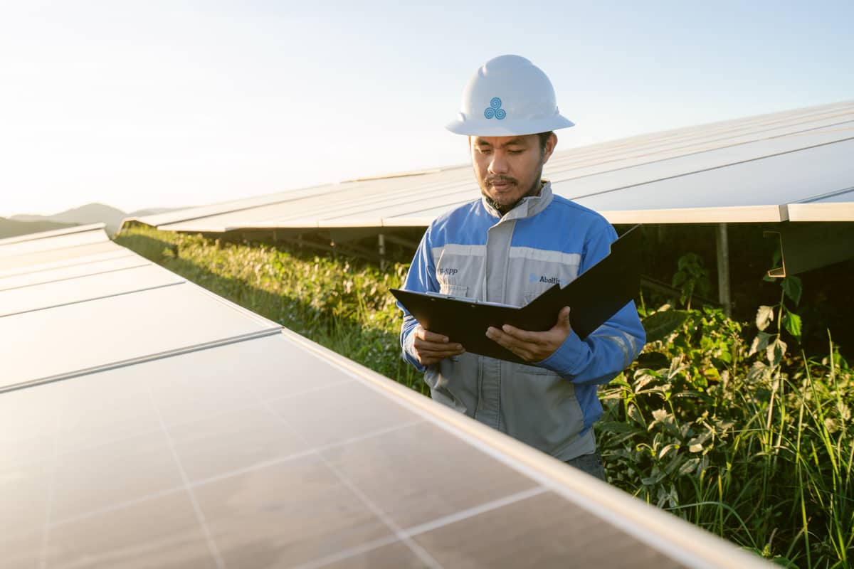 Sunlight meets stewardship An Aboitiz Renewables engineer runs a careful review across a gleaming panel at the 95-MWp Cayanga-Bugallon Solar Farm in Pangasinan, where repurposed sloping land now harvests tomorrow’s power.