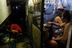 Residents build homes in a tunnel under a busy roadway in Manila
