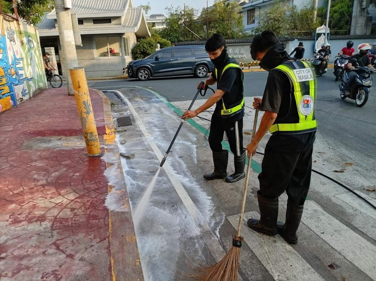 WORKERS from the Department of Environment and Public Services conduct sidewalk flushing along Lubiran in Manila to improve public hygiene and safety.