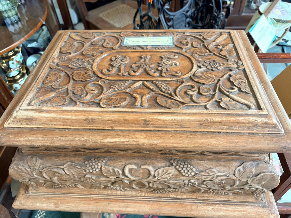 Wooden thread boxes feature intricate designs that highlight traditional needlework tools.