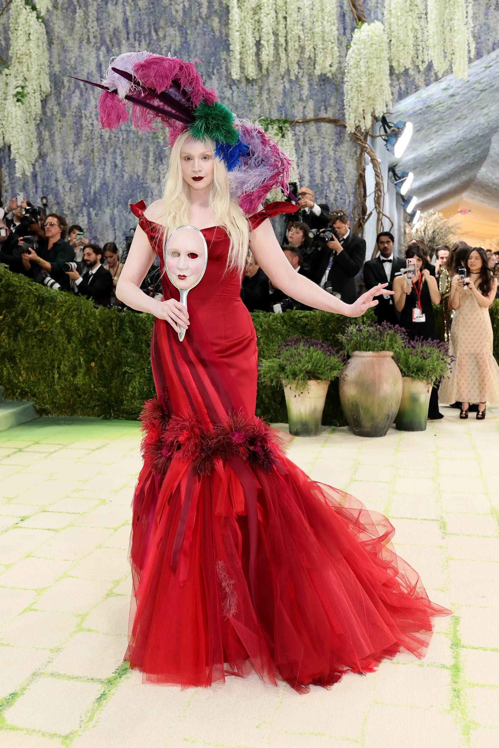 "Game Of Thrones" actress Gwendolynne Christie holds a ceramic mask of her own face by Gillian Wearing is the perfect accessory to her Giles Deacon gown.