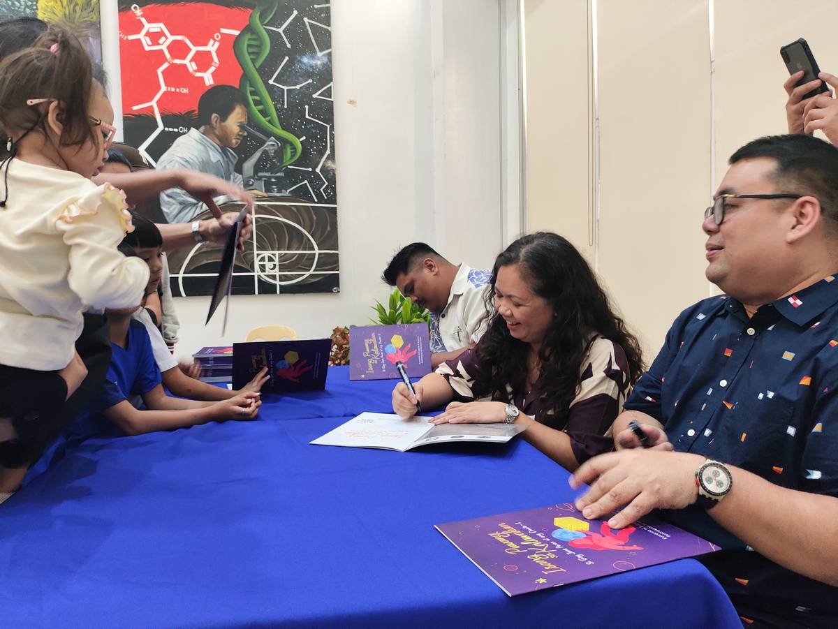 (From left to right) Henrick Dulin, Gay Jane Perez, and Eugene Y. Evasco at the book signing juncture done at the book launch event of the children's book "Isang Puwang sa Kalawakan: Si Gay Jane at ang Diwata-1" was launched Friday at the UP Diliman College of Science Administration Building at Quezon City Friday.