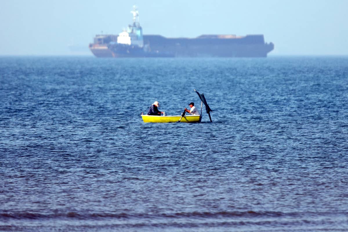 TWO men sitting in a skiff are seen fishing near a vessel anchored in the Strait of Hormuz off Bandar Abbas in southern Iran.