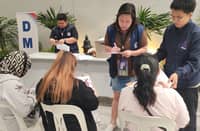 PERSONNEL from the Department of Migrant Workers assist the overseas Filipino workers who were recently repatriated from the Middle East.