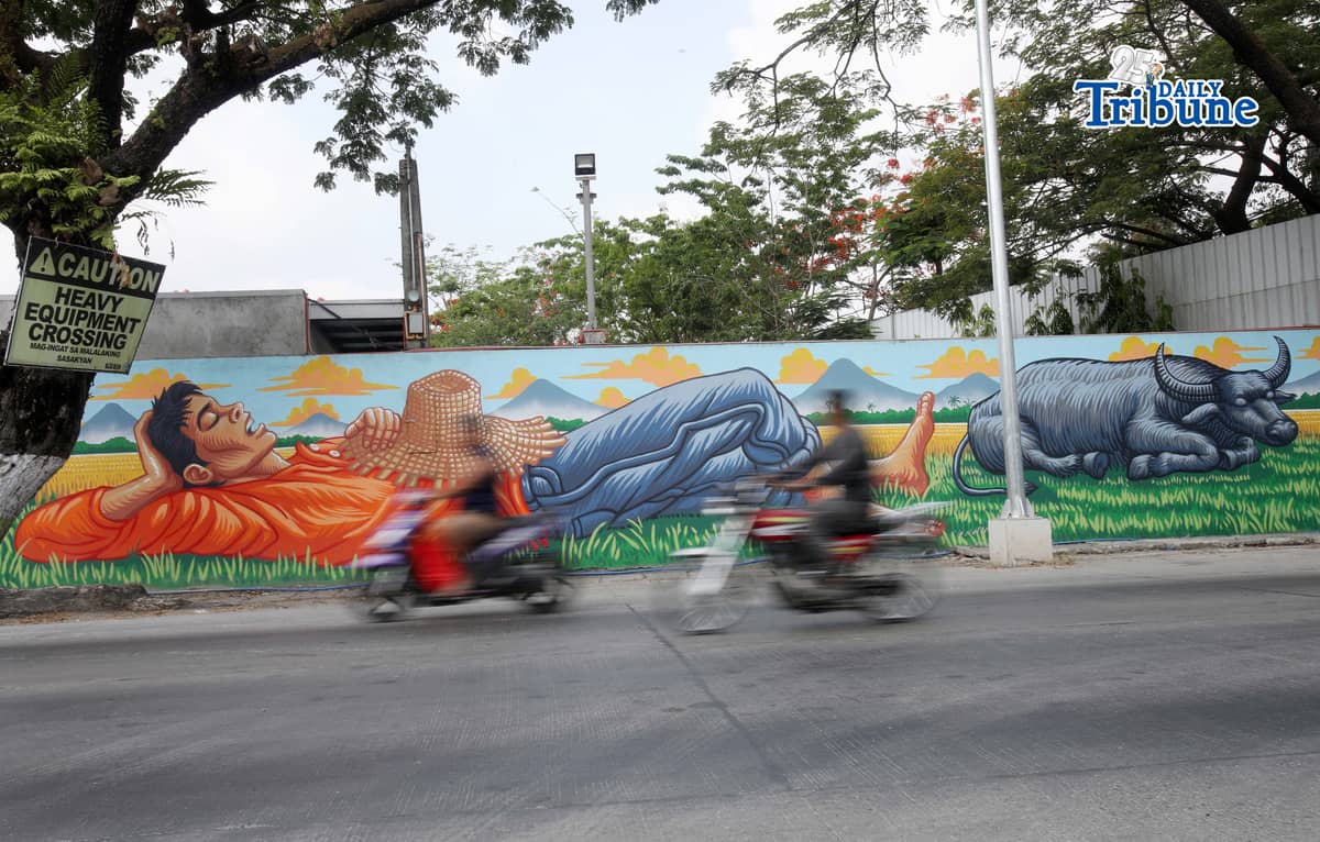 (May 13 2026) Motorists passing at the mural of a Farmer resting and his Carabao along Pulilan regional Road, Pulilan Bulacan on Wednesday May 13 2026, an Artist tribute to San Isidro Labrador the patron saint of farmers, a day of the Pulilan Kneeling Festival a unique, annual cultural and religious event in Pulilan, Bulacan held every 14 and 15 of May to honor San Isidro Labrador. Photo/Analy Labor