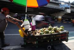 A vendor pushes his cart selling young coconuts, locally known as buko, along EDSA in Quezon City early in the morning as he earns money for his family’s daily expenses.