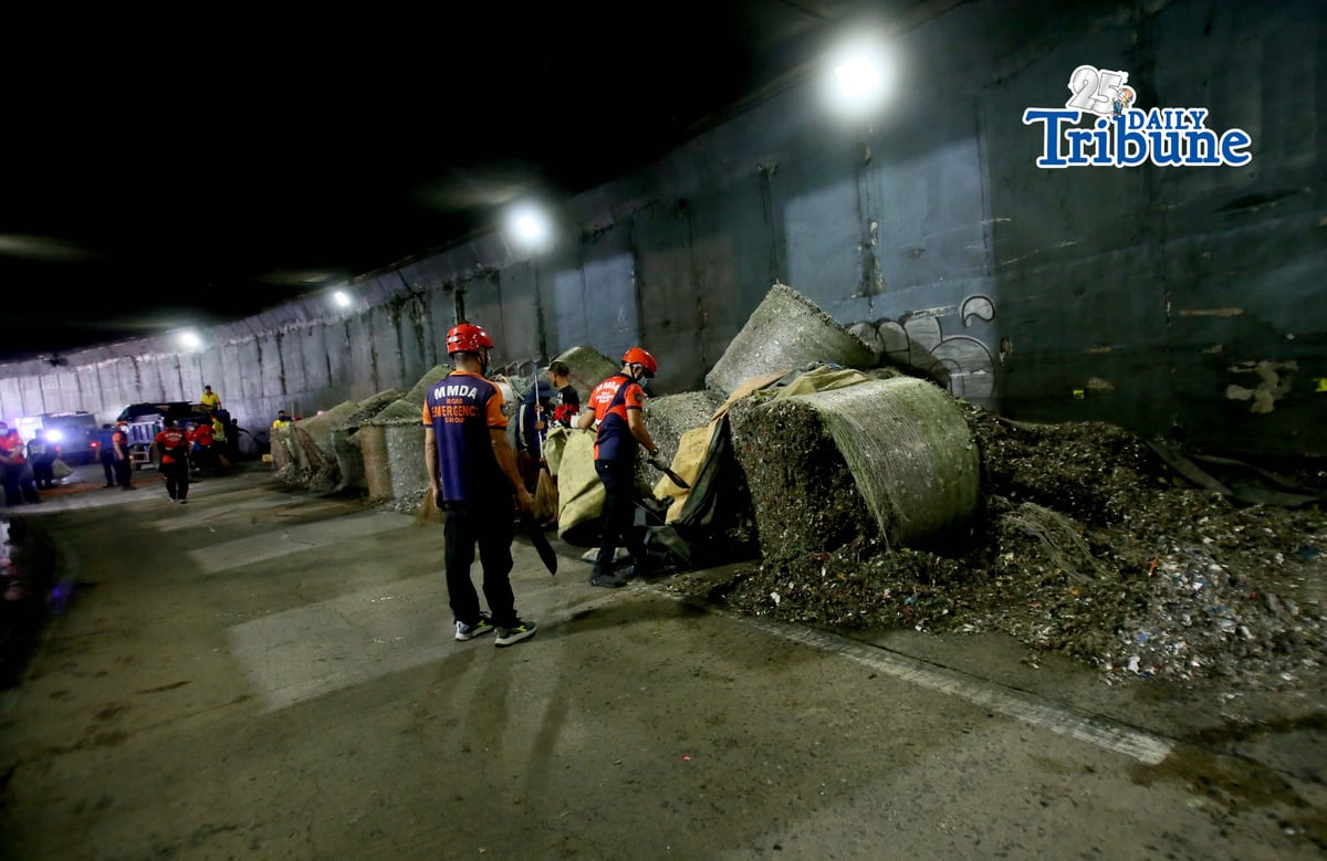 (May 27 2026) The Metropolitan Manila Development Authority (MMDA) street sweepers remove the trash scattered, after a trailer truck loaded with garbage overturned in the southbound lane of the C5-Bonny Serrano Tunnel in Quezon City early Wednesday, May 27, 2026. The incident, which occurred around 5:00 a.m., resulted in the driver and his wife being injured. According to the report, the truck came from Porac, Pampanga, and was heading to Batangas when the vehicle lost control after skidding. Photo/Analy Labor