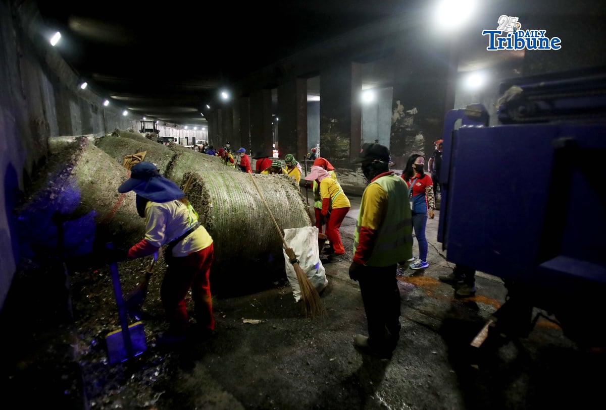 (May 27 2026) The Metropolitan Manila Development Authority (MMDA) street sweepers remove the trash scattered, after a trailer truck loaded with garbage overturned in the southbound lane of the C5-Bonny Serrano Tunnel in Quezon City early Wednesday, May 27, 2026. The incident, which occurred around 5:00 a.m., resulted in the driver and his wife being injured. According to the report, the truck came from Porac, Pampanga, and was heading to Batangas when the vehicle lost control after skidding. Photo/Analy Labor