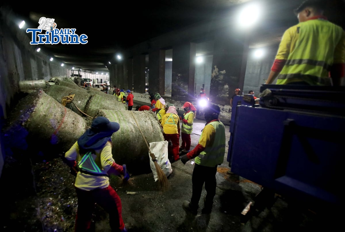 (May 27 2026) The Metropolitan Manila Development Authority (MMDA) street sweepers remove the trash scattered, after a trailer truck loaded with garbage overturned in the southbound lane of the C5-Bonny Serrano Tunnel in Quezon City early Wednesday, May 27, 2026. The incident, which occurred around 5:00 a.m., resulted in the driver and his wife being injured. According to the report, the truck came from Porac, Pampanga, and was heading to Batangas when the vehicle lost control after skidding. Photo/Analy Labor