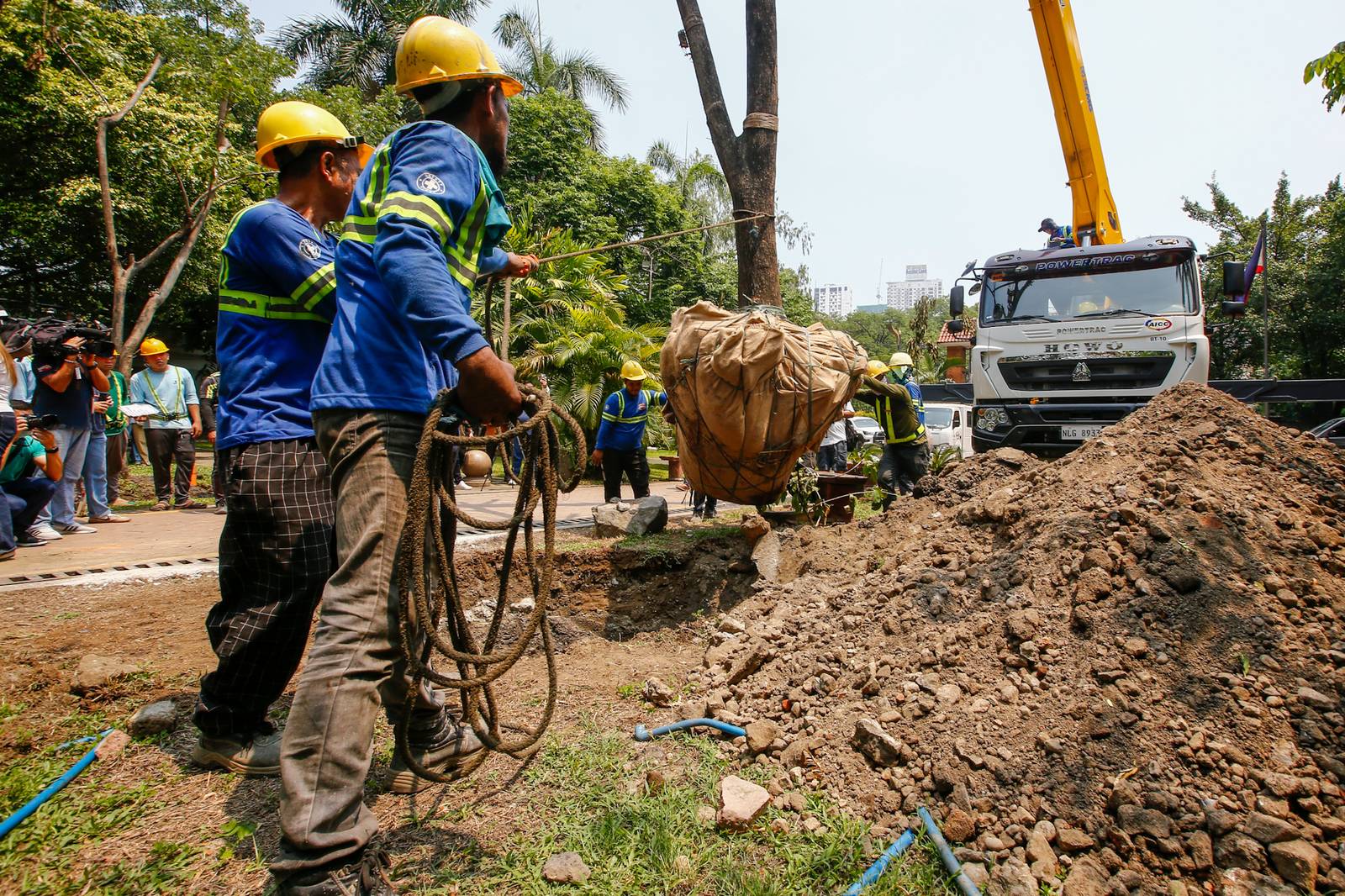 Workers from the Department of Environment and Natural Resources (DENR) transplant two Narra trees at the Hidden Garden in Manila on 28 May 2026. The trees were earthballed from Quirino Avenue to make way for a segment of San Miguel Corporation's 40.6-kilometer Southern Access Link Expressway (SALEx) project. DENR Secretary Juan Miguel Cuna ordered a suspension of the tree-cutting and earthballing activities following intense protests from environmental groups.